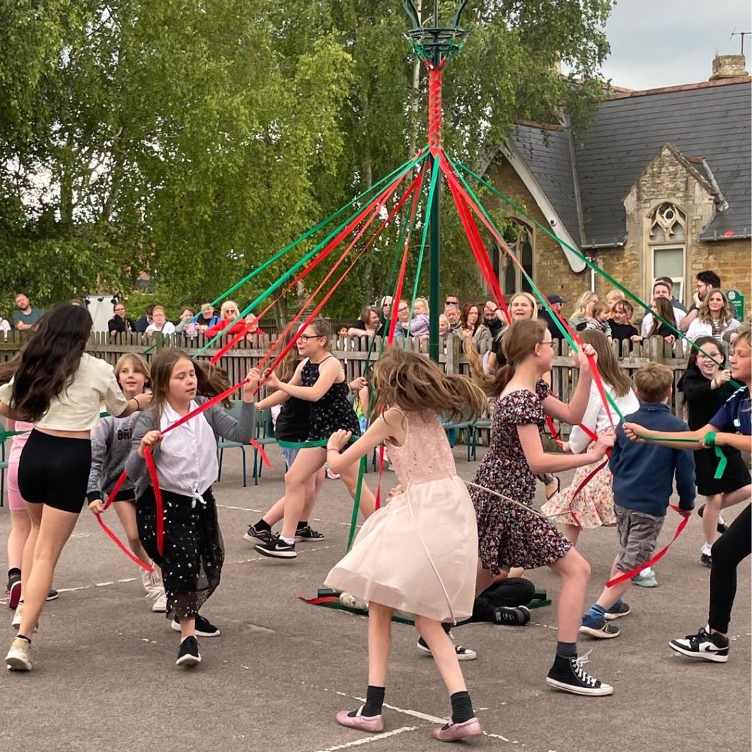 children dancing around a May pole