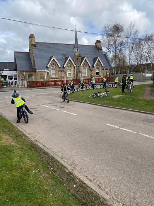 children on bikes outside of the school building